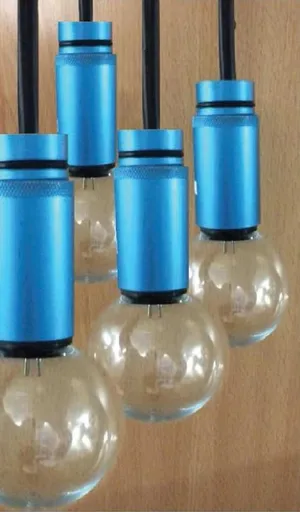 Pendant festoons bulbs with blue casings against wooden backdrop