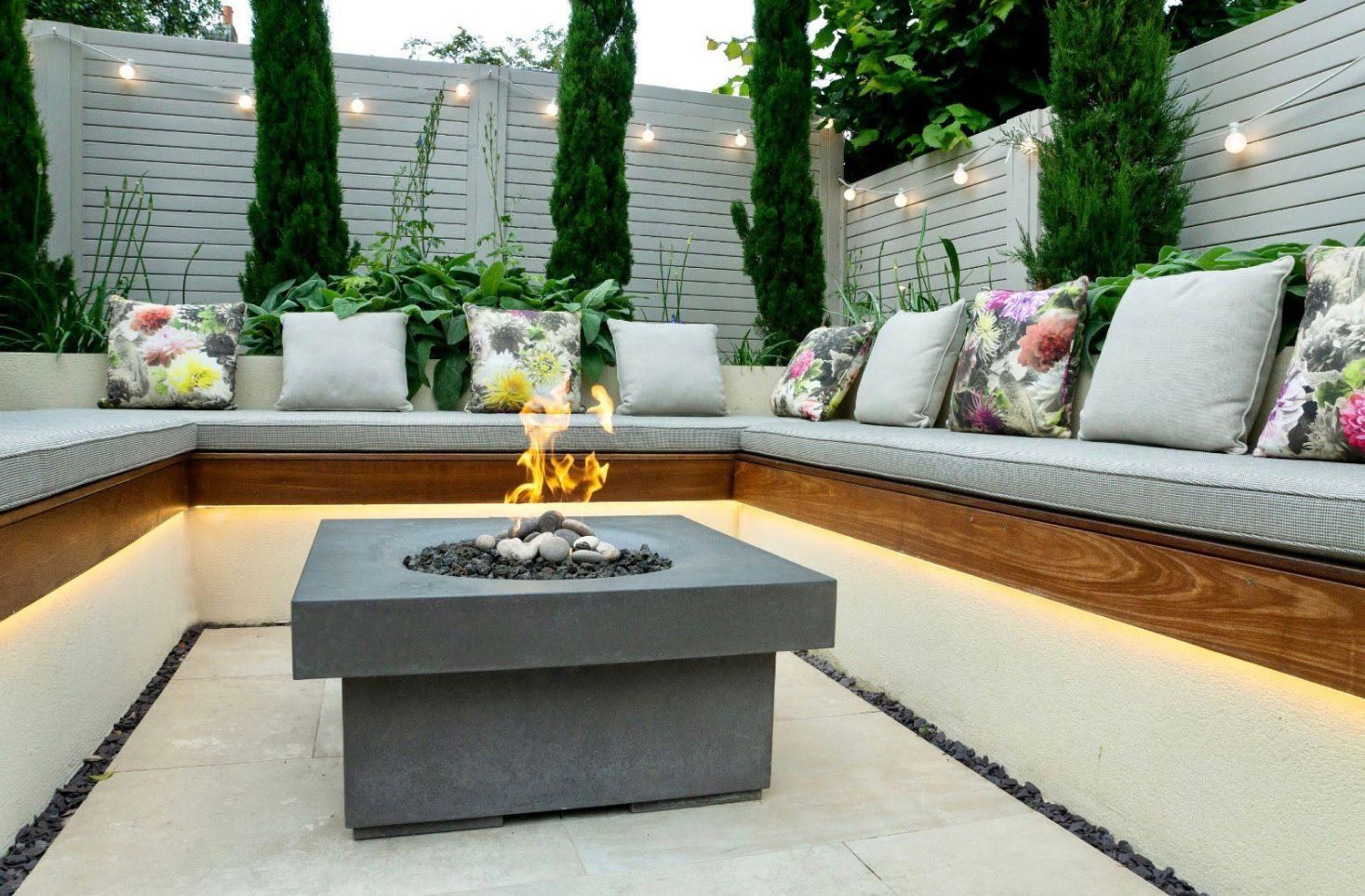 Festoon lighting in garden with fire pit