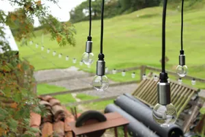 Several pendant festoon lights hanging in garden