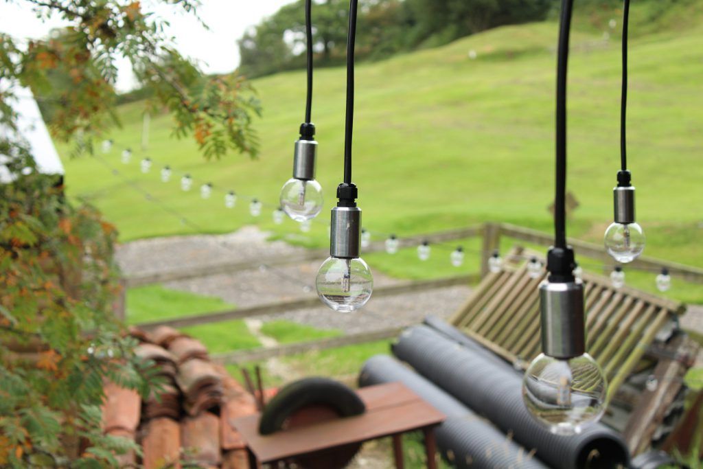Several pendant festoon lights hanging in garden