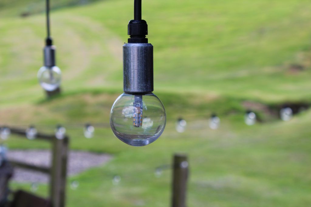 Soft focus image of pendant festoon lights hanging in garden